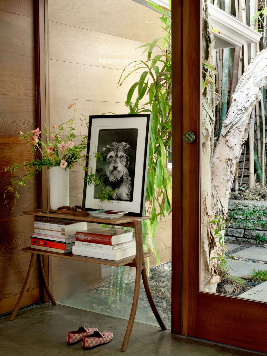 Phần cửa trước với kệ sách nhỏ, bình hoa tươi tắn và bức tranh chú chó của Dakota Johnson