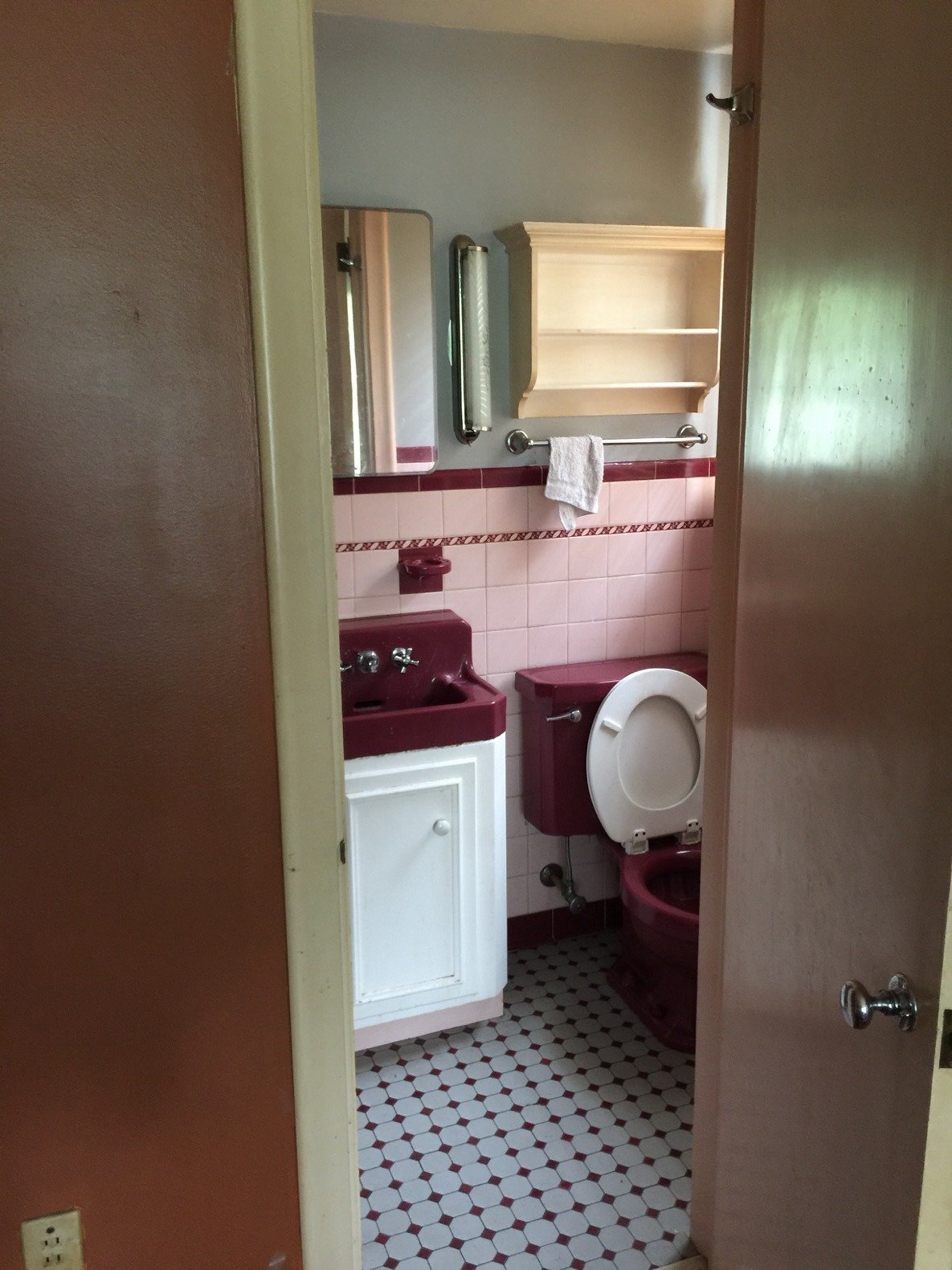 The master bathroom was very small and came with a maroon toilet and a matching sink that the team decided to keep, although the white toilet lid was swapped. 