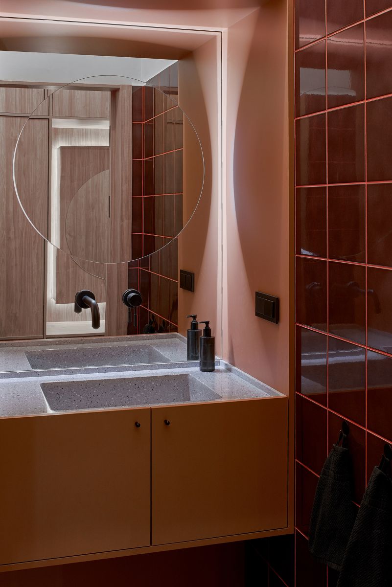 Phòng tắm nhỏ sử dụng gạch ốp tường màu đỏ đun cùng ánh sáng dịu nhẹ tạo ra không gian rất riêng tư